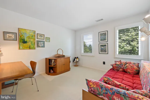 a bathroom with a granite countertop sink a toilet a mirror and window