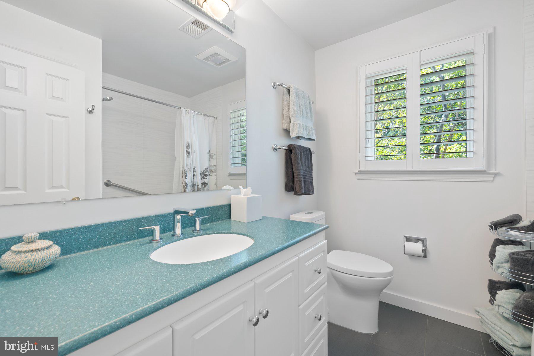 16400 Montecrest Lane Gaithersburg, MD 20878 - Photo 34 of 58 a bathroom with a granite countertop sink a toilet a mirror and window