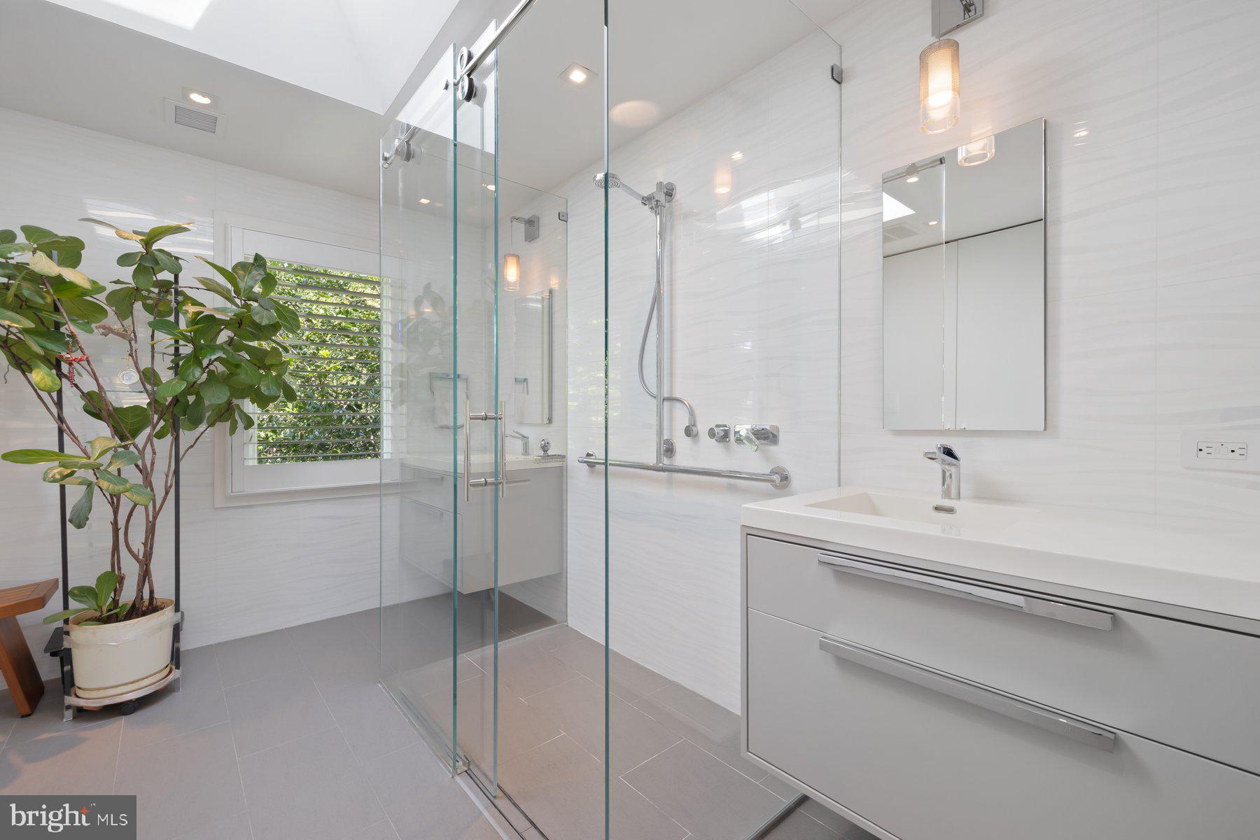 16400 Montecrest Lane Gaithersburg, MD 20878 - Photo 40 of 58 a bathroom with a sink a large mirror and a shower