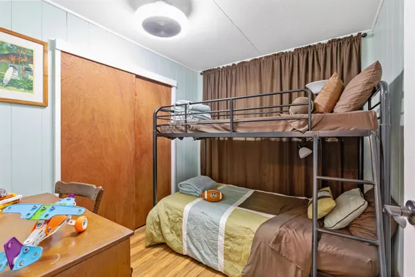 a bedroom with a bed and wooden floor