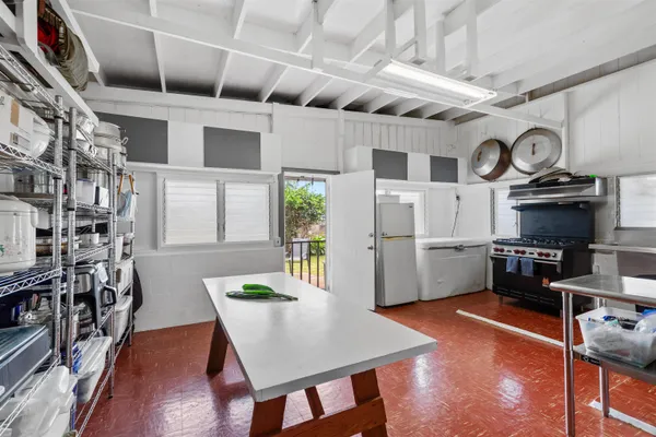 a kitchen with stainless steel appliances granite countertop a stove a refrigerator a oven a white table and chairs with wooden floor