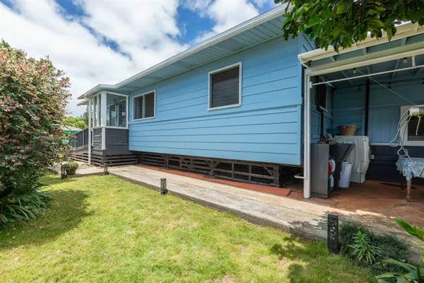 a view of a house with a patio and a yard