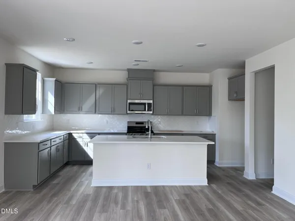 a kitchen with stainless steel appliances granite countertop a sink a stove and a refrigerator