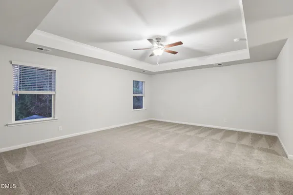 an empty room with windows and fan