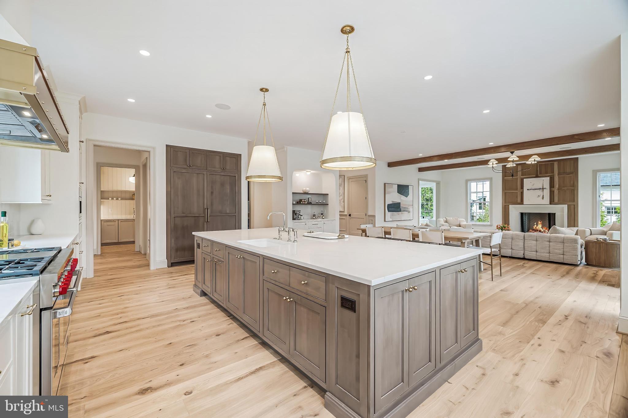 6913 Benjamin Street McLean, VA 22101 - Photo 22 of 51 a large kitchen with kitchen island a stove a sink a center island and a wooden floor