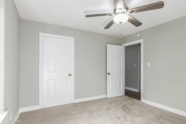an empty room with chandelier fan