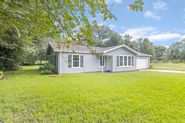a view of a house with backyard and garden