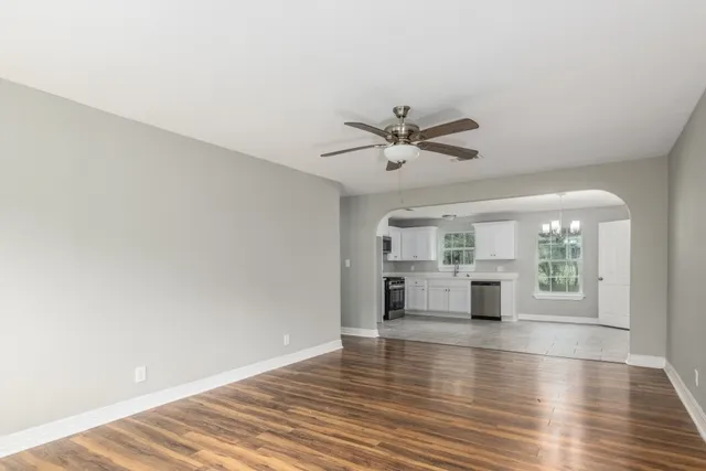 an empty room with wooden floor and window