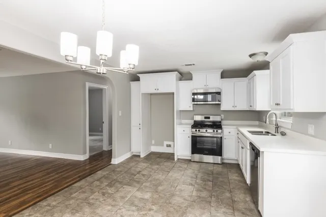 a kitchen with kitchen island granite countertop a sink cabinets and stainless steel appliances