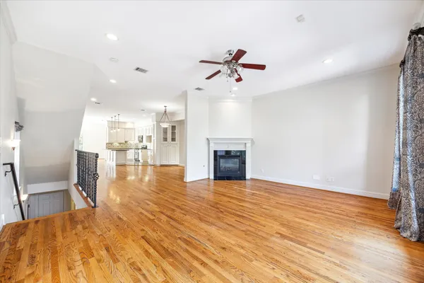 a view of a room with wooden floor fire place and kitchen view