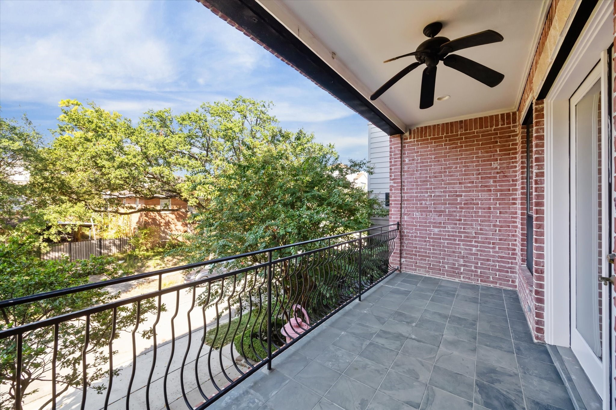 1231 West Pierce Street Houston, TX 77019 - Photo 13 of 33 Finished with tile flooring and a ceiling fan, this wide balcony is the perfect destination for morning coffee or after-dinner drinks overlooking treetop views.