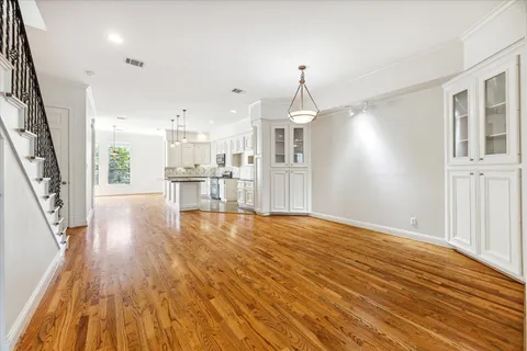 a view of a kitchen with wooden floor and an empty room