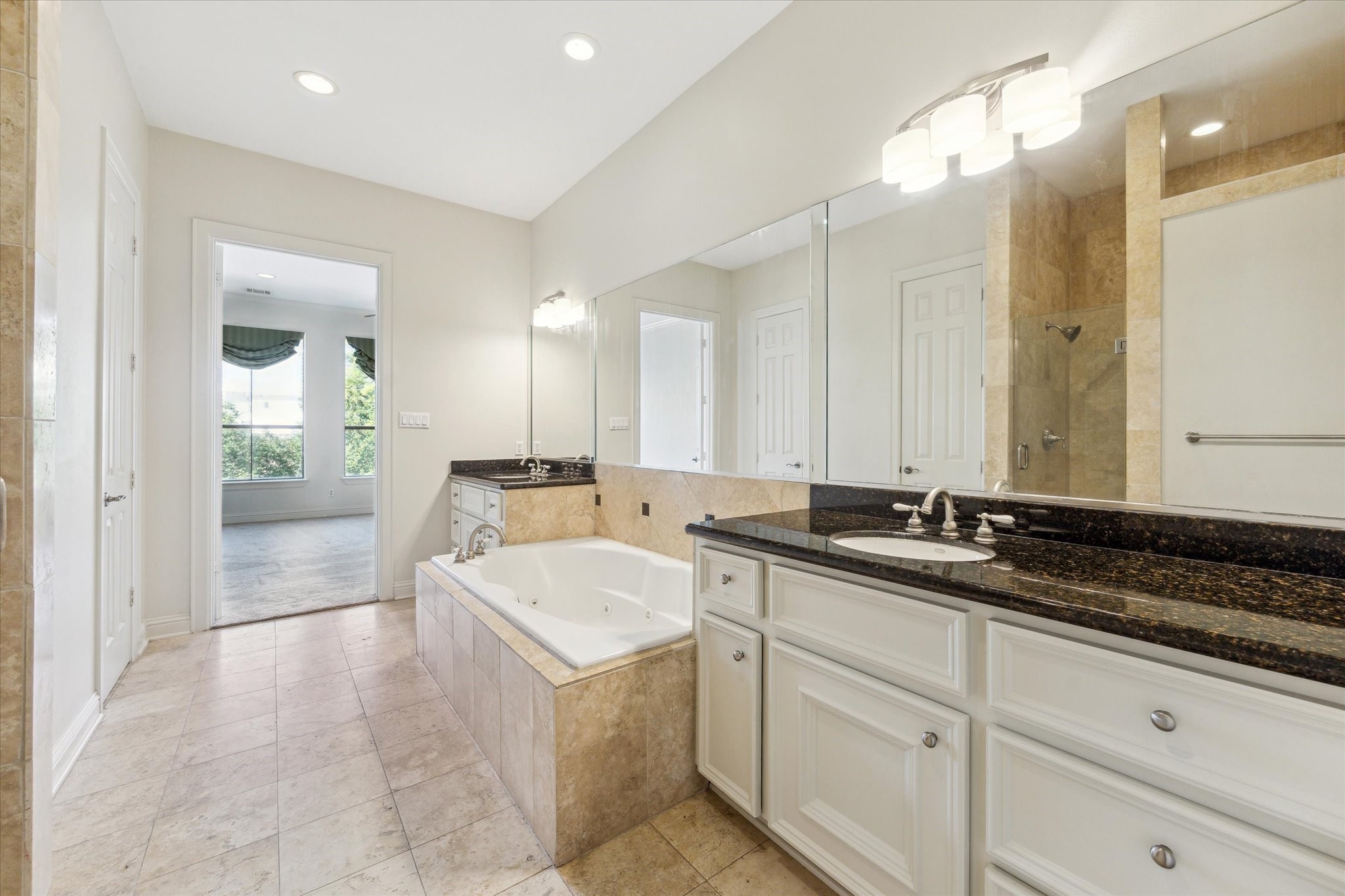 1231 West Pierce Street Houston, TX 77019 - Photo 27 of 33 Lovely travertine tile and granite countertops run throughout the primary spa bath.
