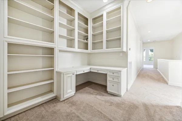 a view of an empty room with white cabinet and a window