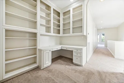 a view of an empty room with white cabinet and a window