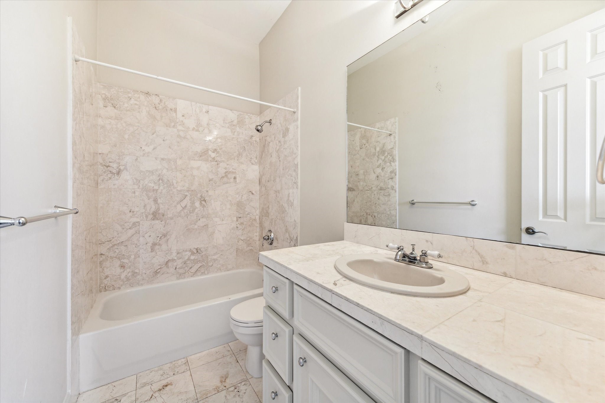 1231 West Pierce Street Houston, TX 77019 - Photo 32 of 33 The top floor’s secondary bathroom includes a large vanity and tub/shower wrapped in pale stone tile.