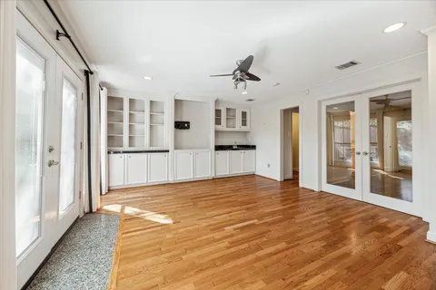 a view of empty room with wooden floor and windows