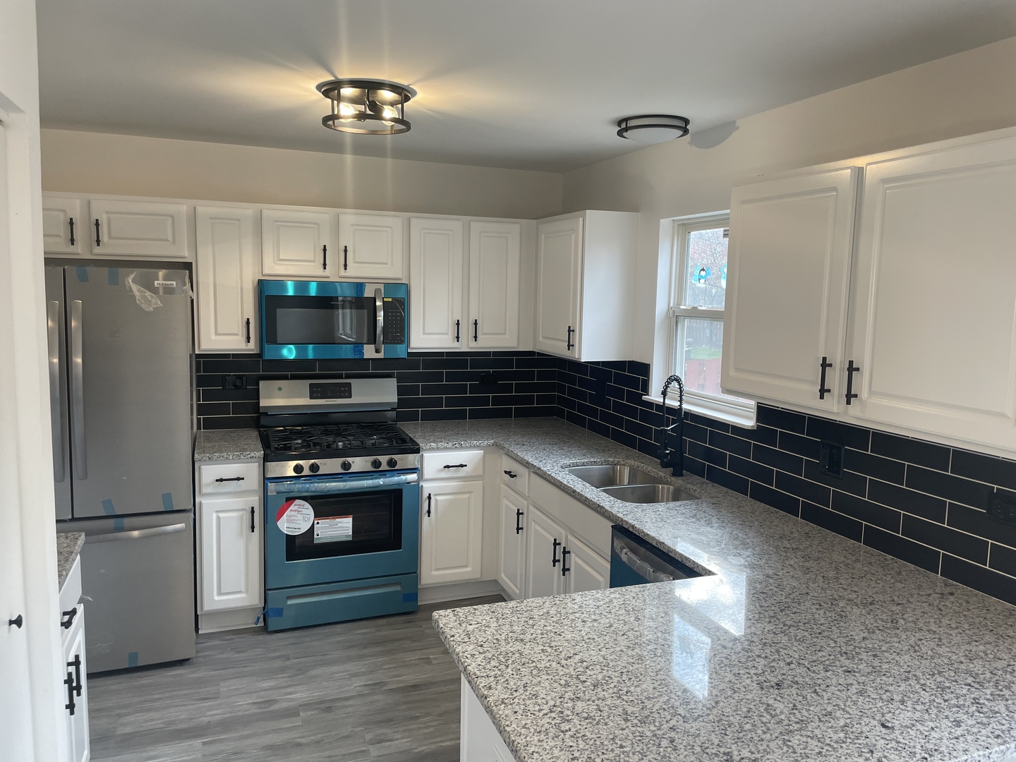 Undisclosed Address Round Lake, IL 60073 - Photo 4 of 15 a kitchen with stainless steel appliances granite countertop a refrigerator a stove and a sink