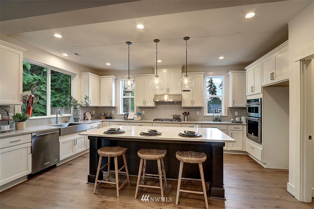 5 232nd Place Southeast Bothell, WA 98021 - Photo 4 of 21 a kitchen with stainless steel appliances granite countertop a stove a sink a refrigerator a dining table and chairs