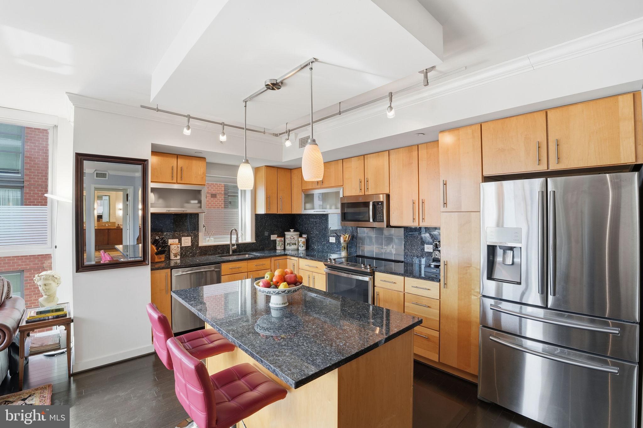 1025 First Street Southeast, Unit 906 Washington, DC 20003 - Photo 3 of 30 a kitchen with stainless steel appliances granite countertop a refrigerator a sink a stove and island