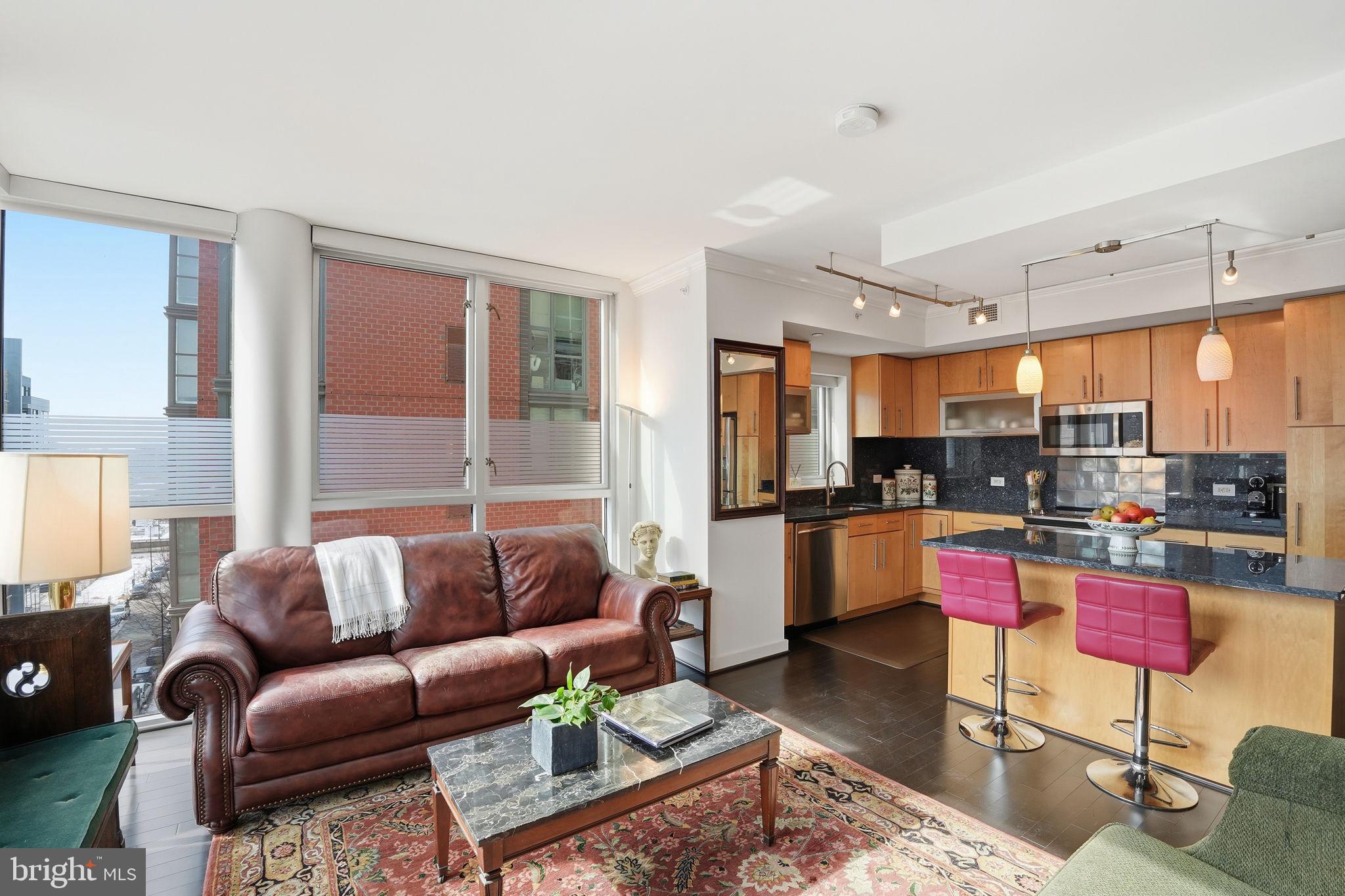 1025 First Street Southeast, Unit 906 Washington, DC 20003 - Photo 7 of 30 a living room with furniture kitchen view and a large window