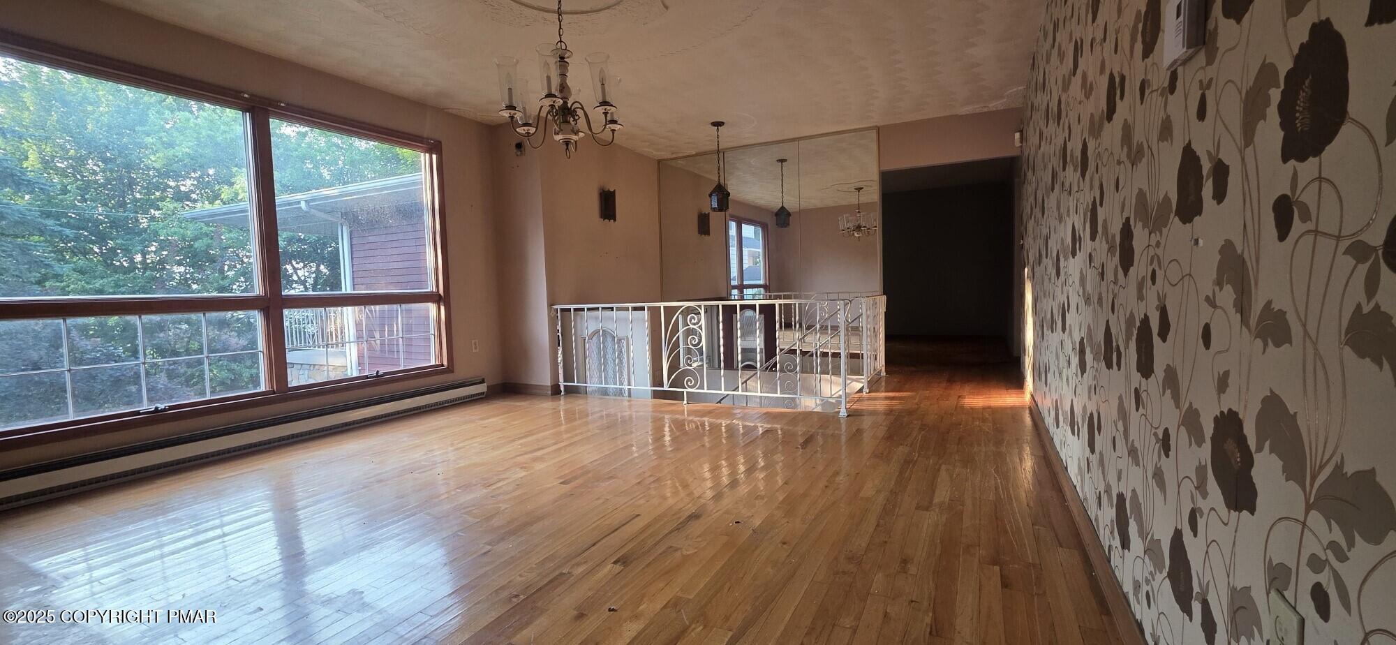 1829 South Webster Avenue Scranton, PA 18505 - Photo 16 of 40 a view of a room with wooden floor a ceiling fan and windows