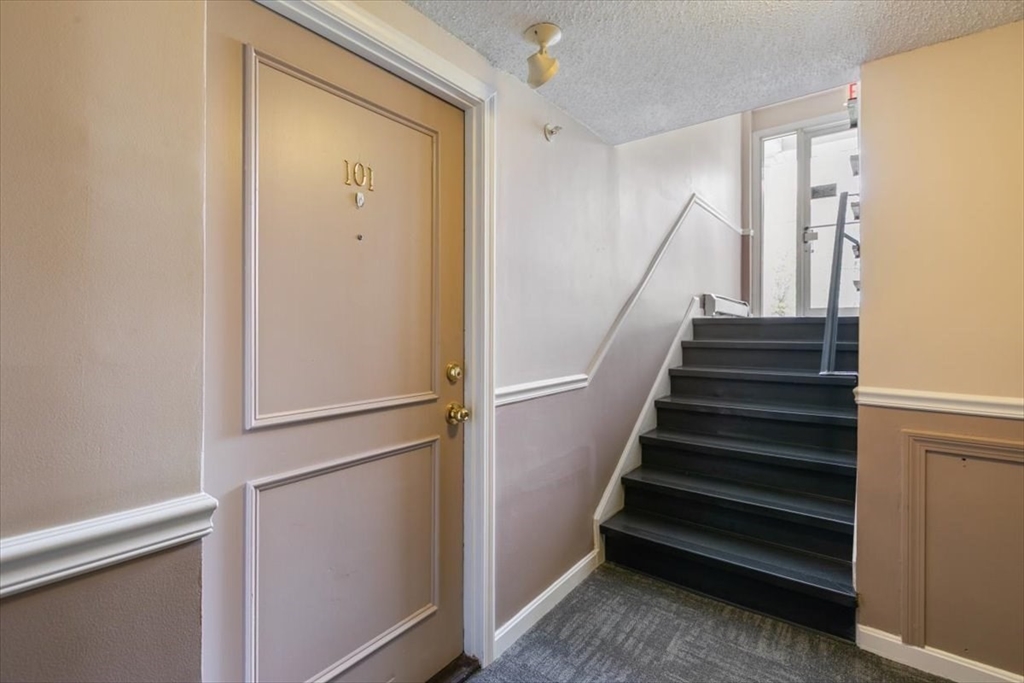 25 Clark's Road, Unit 101 Amesbury, MA 01913 - Photo 5 of 32 a view of entryway with wooden floor and stairs