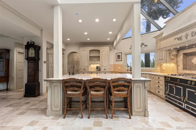 a dining hall with stainless steel appliances granite countertop a stove and a sink