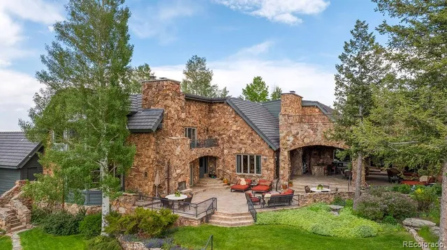 a view of a patio with table and chairs potted plants and a large tree