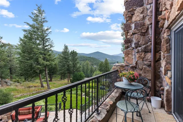 a view of a balcony with chairs and a potted plant