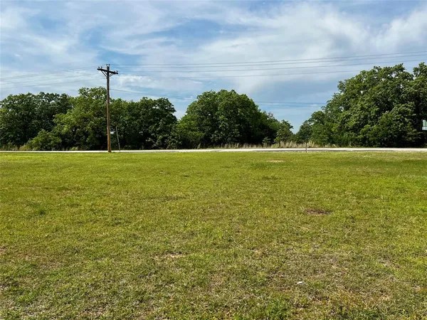 a view of a field with an ocean in the background