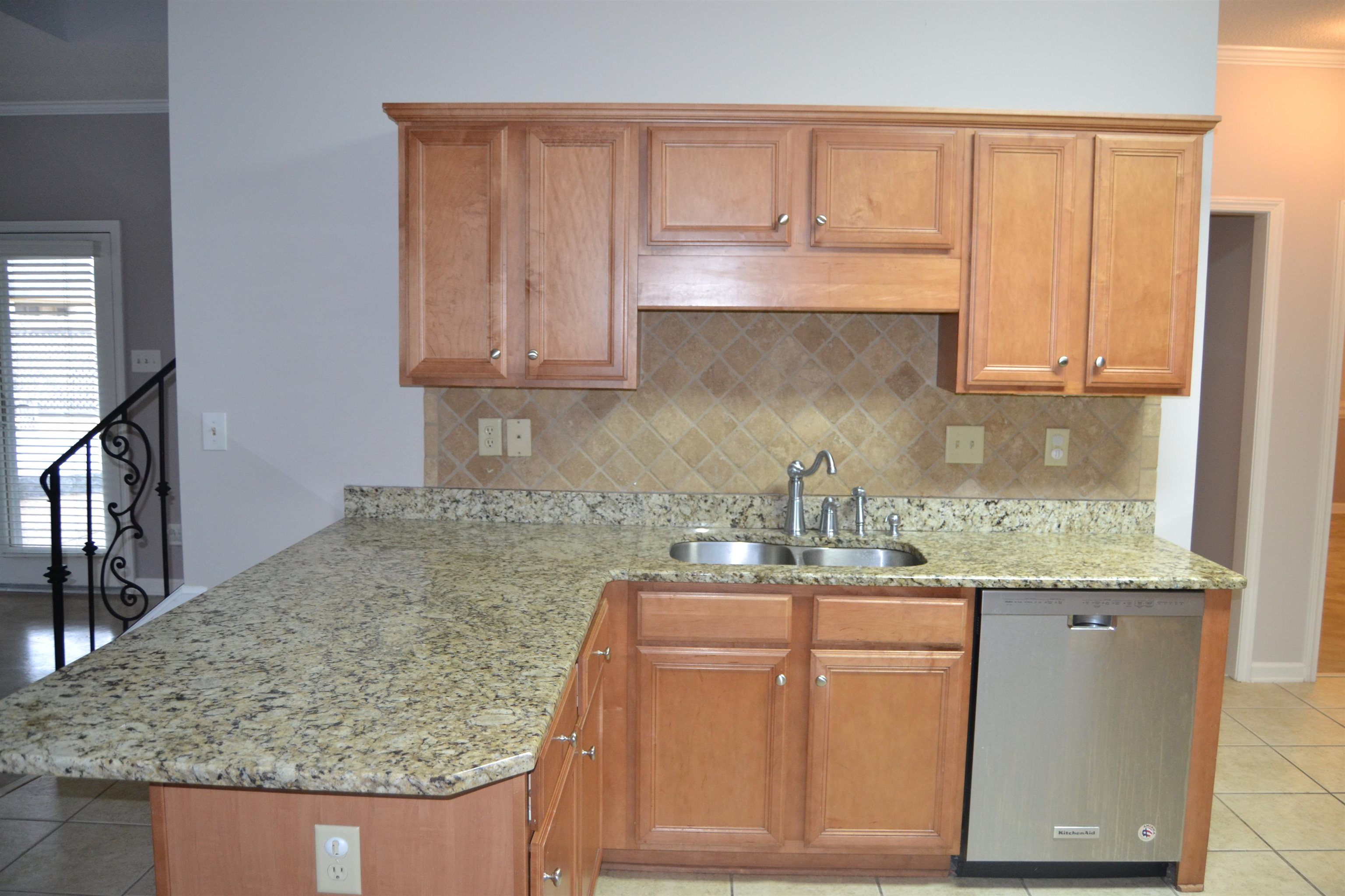 10486 Juneau Way Collierville, TN 38017 - Photo 16 of 33 Kitchen with dishwasher, crown molding, sink, light stone countertops, and kitchen peninsula