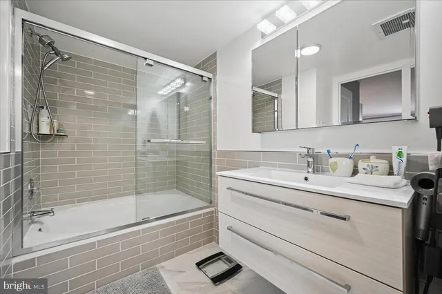 a bathroom with a granite countertop sink a toilet and shower