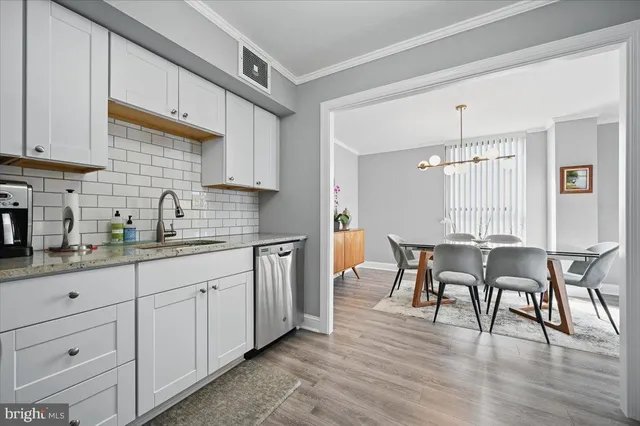 a kitchen with granite countertop white cabinets dining table and chairs