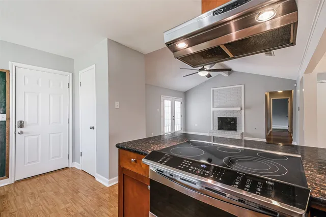 a living room with stainless steel appliances granite countertop a stove and a refrigerator