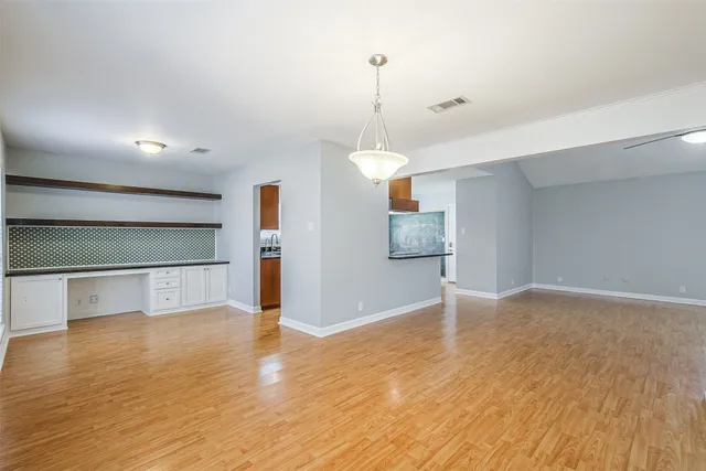 a view of empty room with wooden floor