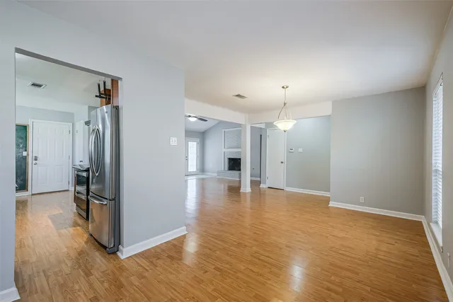 a view of a hallway with wooden floor and a living room