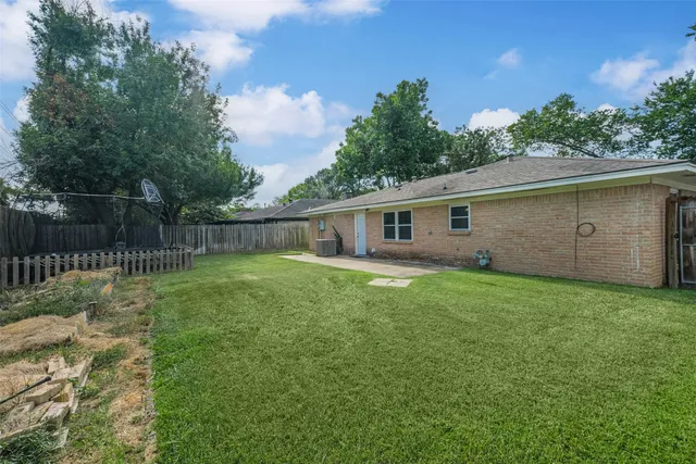 a view of a backyard with plants and a fence