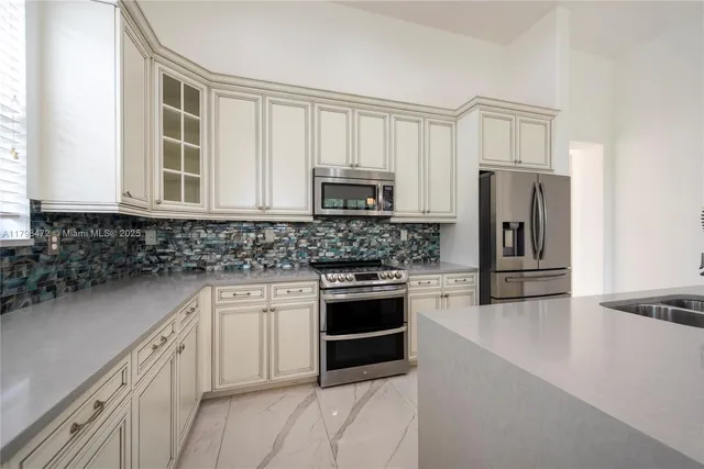a kitchen with stainless steel appliances granite countertop a sink and a stove