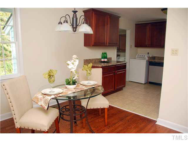 1217 North King Charles Road Raleigh, NC 27610 - Photo 7 of 17 a kitchen with granite countertop a table chairs stove and cabinets