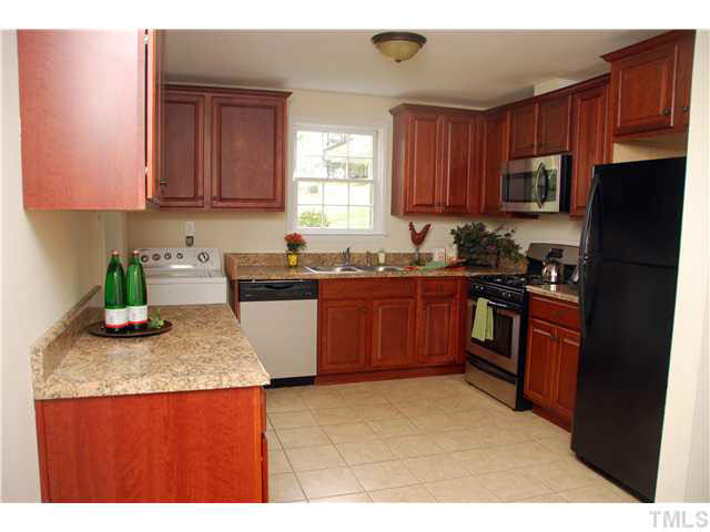 1217 North King Charles Road Raleigh, NC 27610 - Photo 8 of 17 a kitchen with stainless steel appliances granite countertop wooden cabinets a stove top oven with granite countertops and wooden cabinets