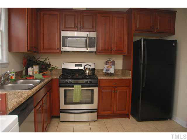 1217 North King Charles Road Raleigh, NC 27610 - Photo 9 of 17 a kitchen with stainless steel appliances granite countertop a stove a refrigerator and a microwave