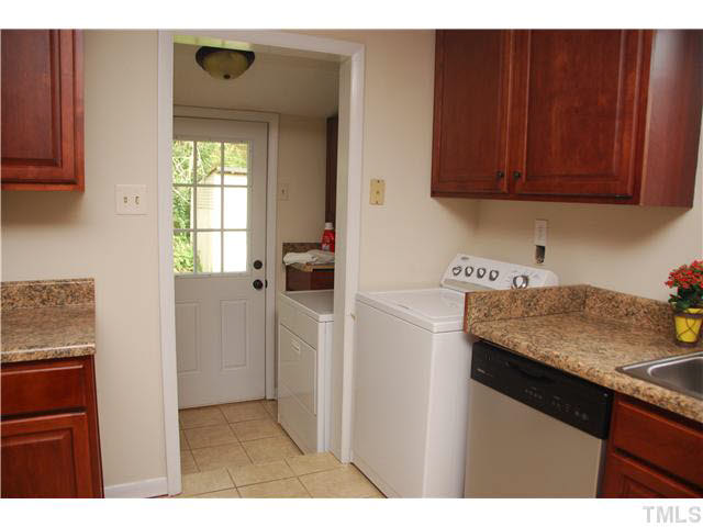 1217 North King Charles Road Raleigh, NC 27610 - Photo 10 of 17 a kitchen with a sink a refrigerator and cabinets