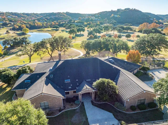an aerial view of a house with a yard and lake view