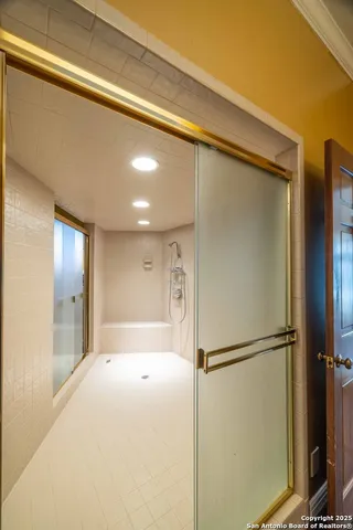 a bathroom with a shower and a glass door