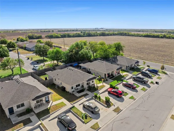 an aerial view of multiple houses with yard