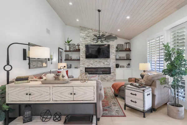 a living room with furniture a flat screen tv and a fireplace