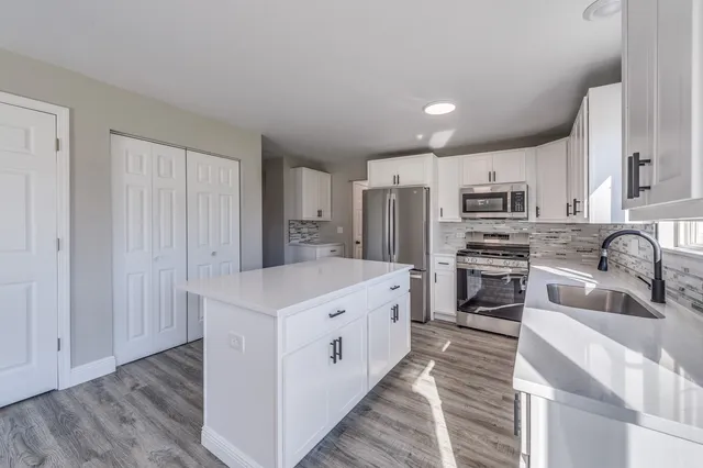 a kitchen with stainless steel appliances a refrigerator sink and cabinets