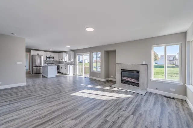 a view of empty room with wooden floor and fireplace