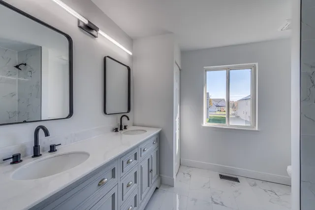 a bathroom with 2 sink and a mirror